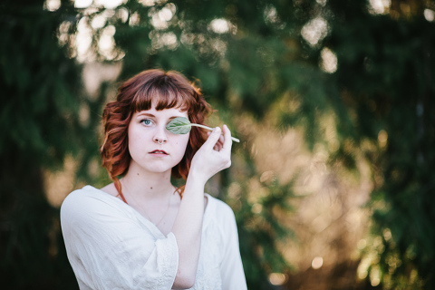 girl with leaf covering eye