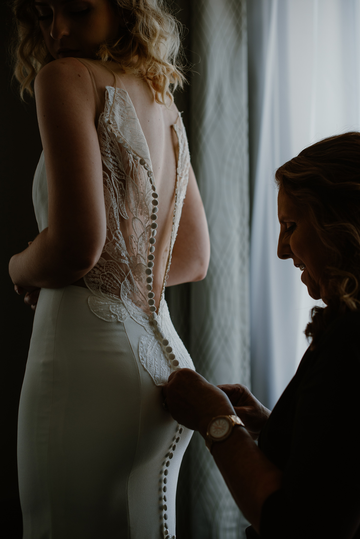 Mother helping daughter into wedding dress at The Loft 132