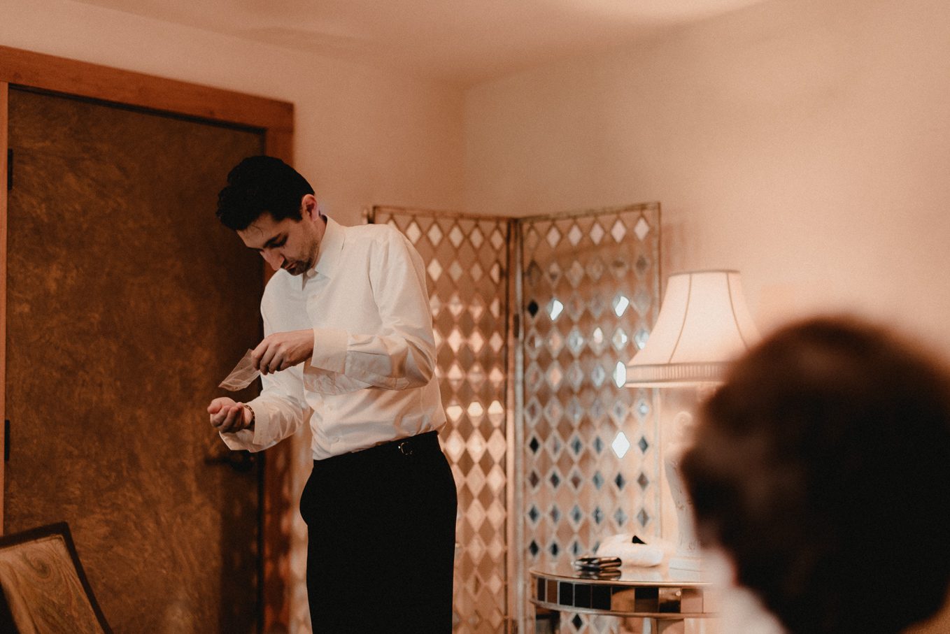 Groom getting ready at winery in Pepin.