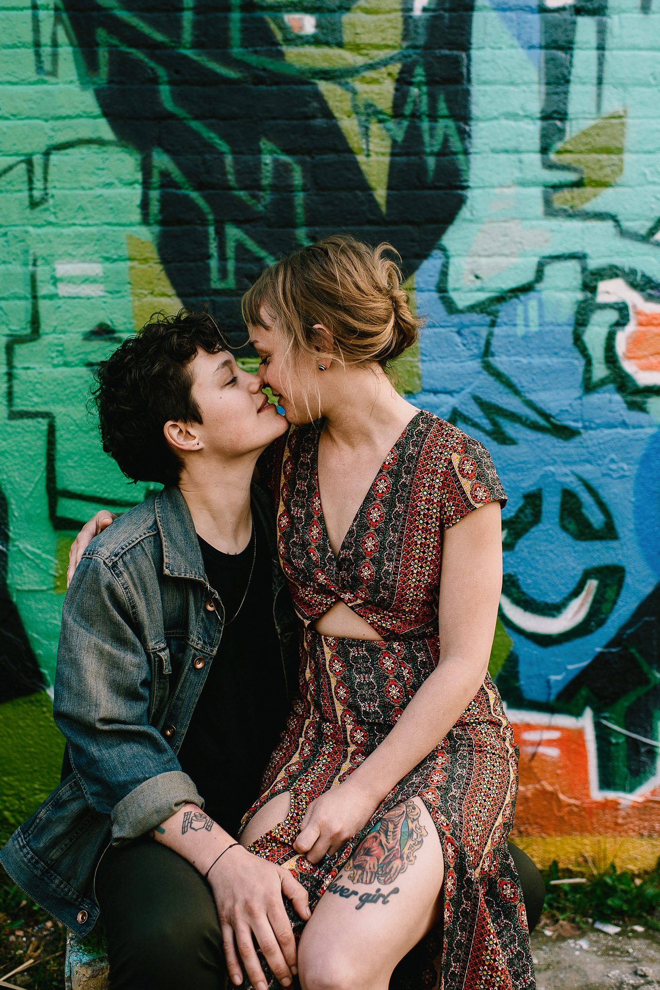 kisses in front of graffiti wall downtown madison