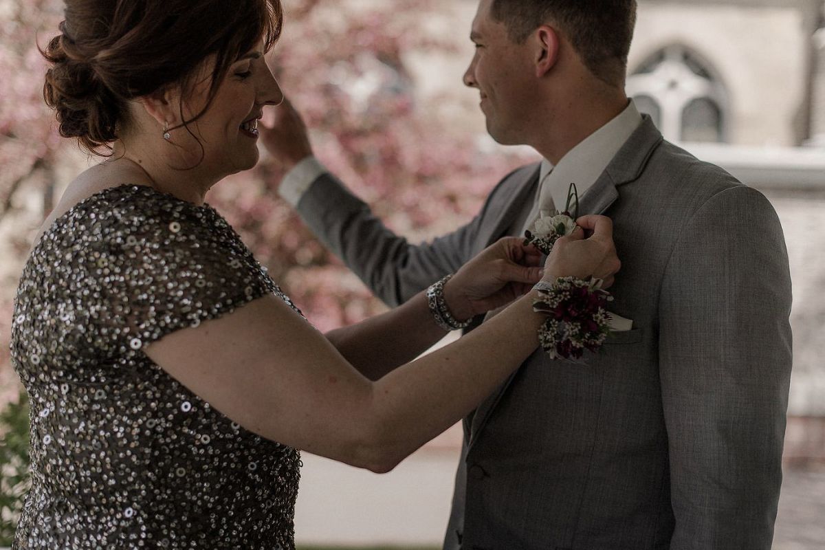 Groom's mother pinning boutonniere