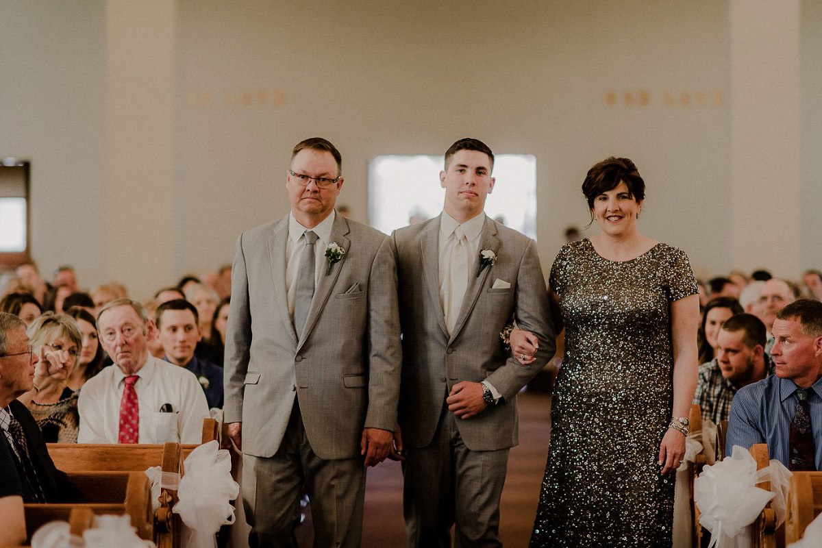 Groom walking mother and father to their seats