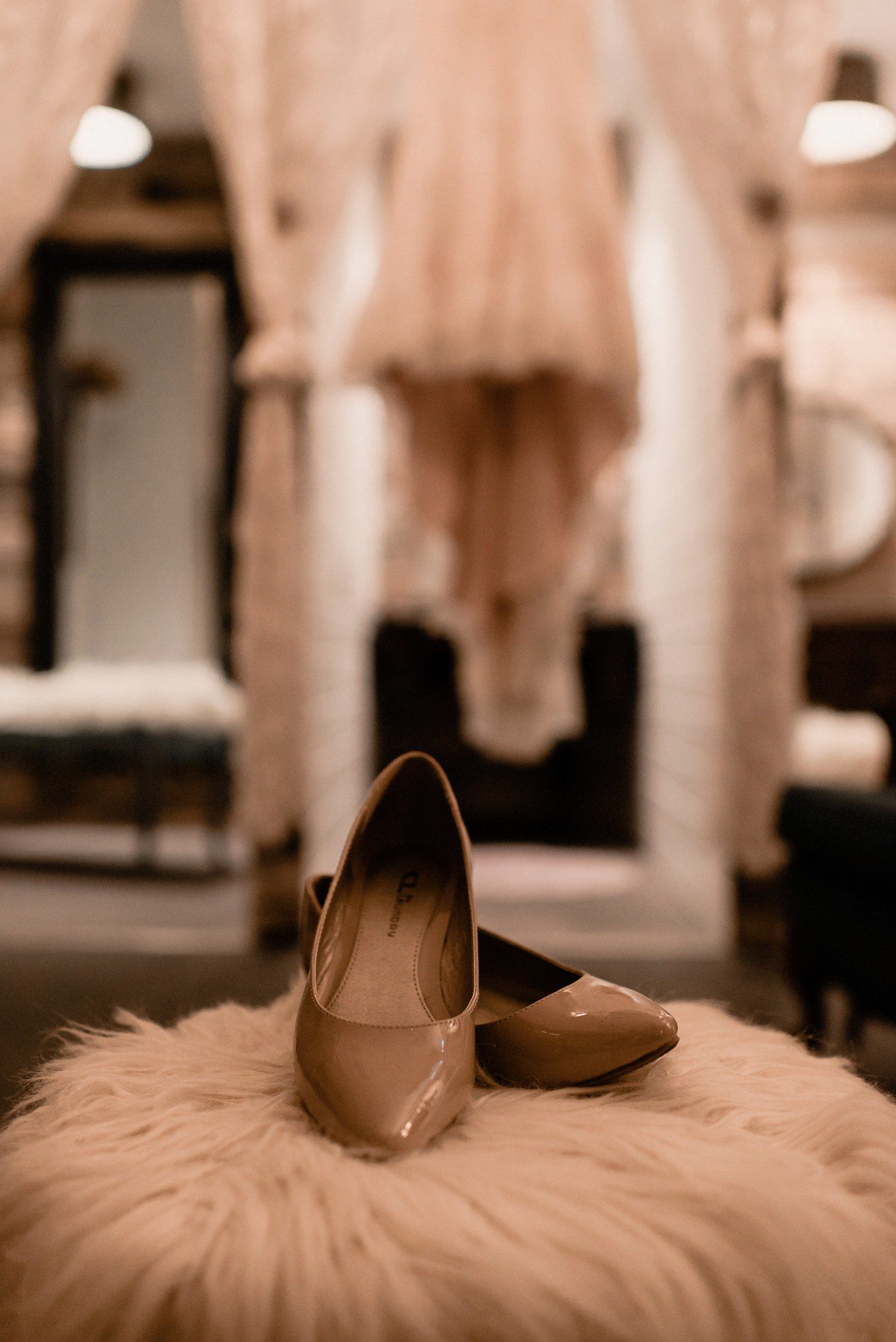 Bridal shoe detail shot with dress behind shoes