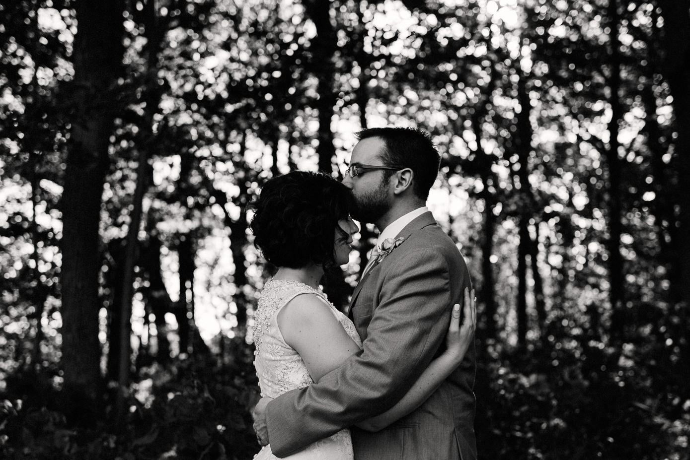 Groom kissing his bride's forehead