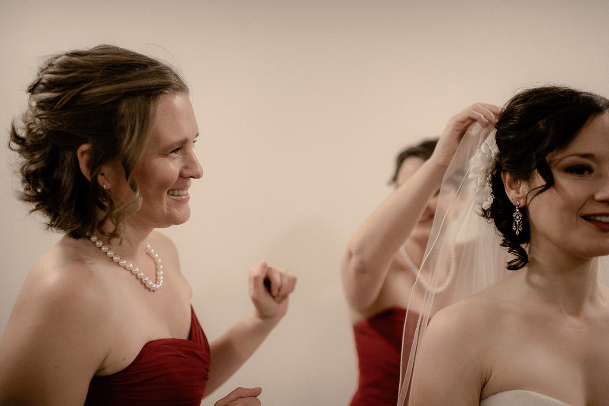 Bridesmaid's helping bride with her veil