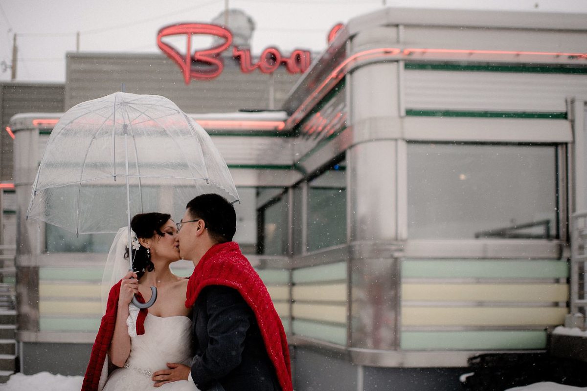 Wedding couple kissing outside of Baraboo Broadway Diner