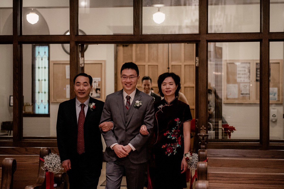 Parents walking groom down the aisle at St Joseph's Catholic Church