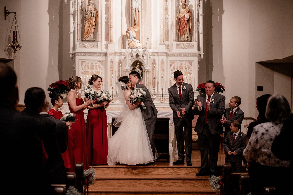 Groom kissing his bride on St Joseph's Catholic Church altar