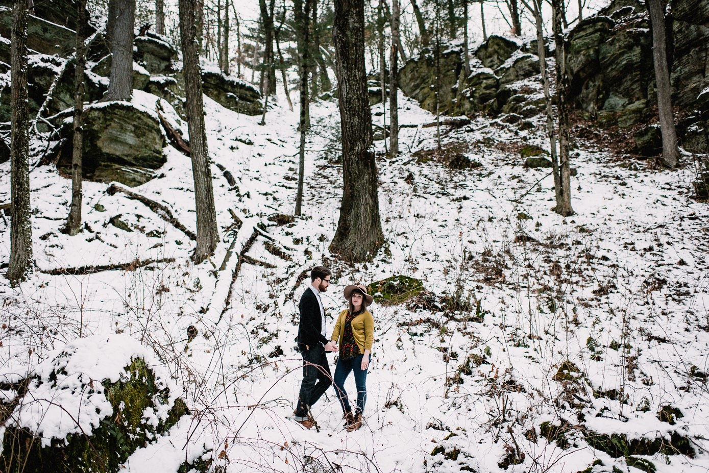 Husband and wife surrounded by snow and cliffs