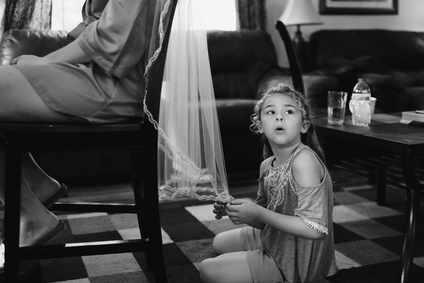 Flower girl playing with bride's veil.