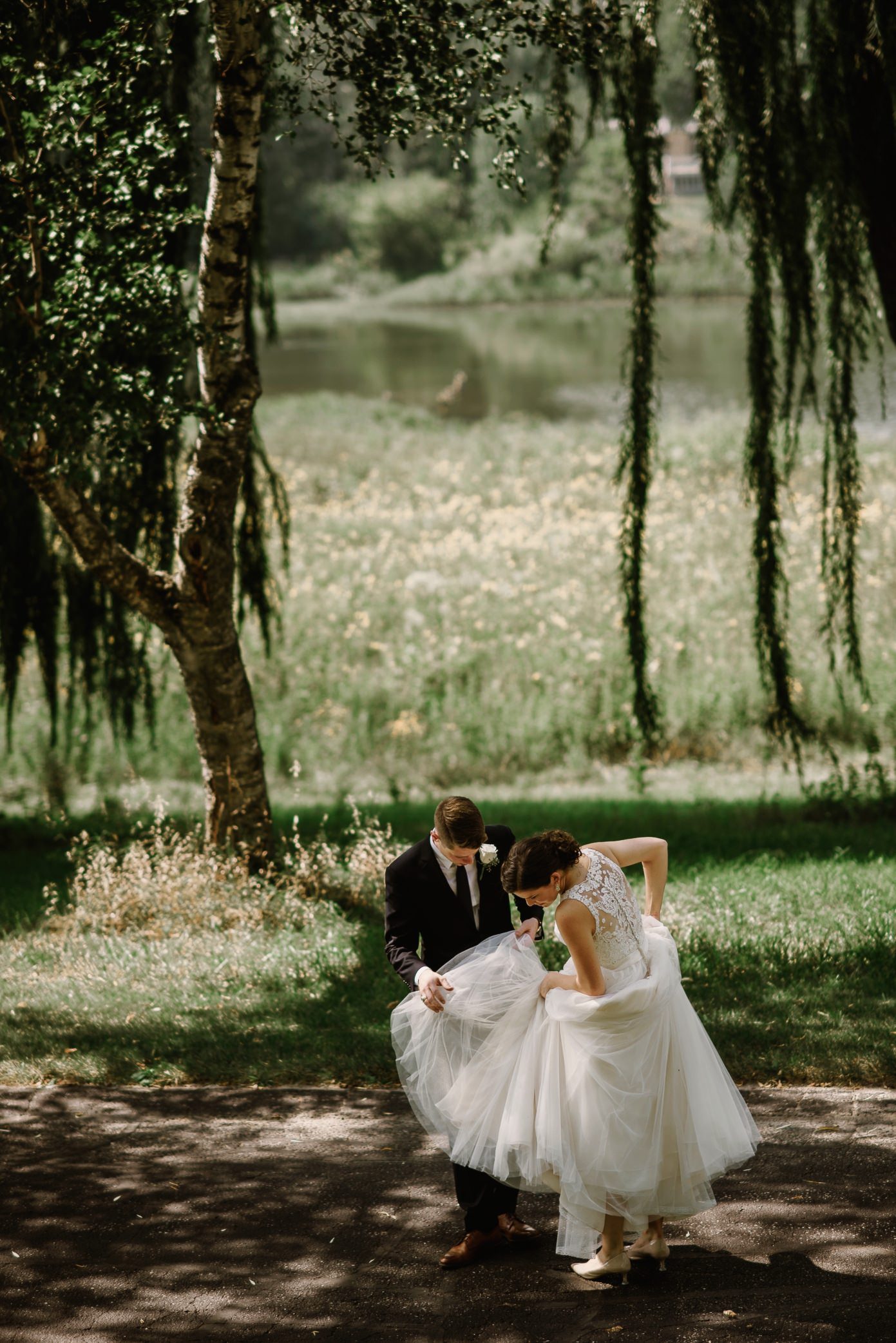 Groom helping bride with dress