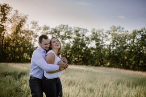 Madison engagement session with couple laughing in a field