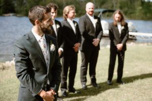 Groom watching bride walk down aisle