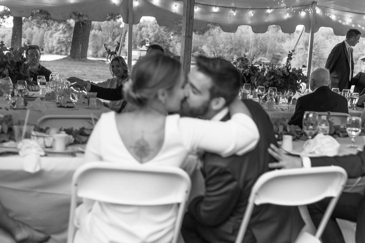 Bride and groom kissing during dinner