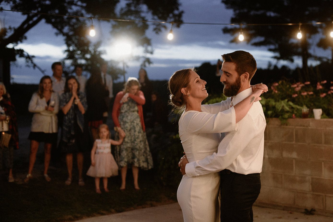 bride and groom first dance under bistro lights