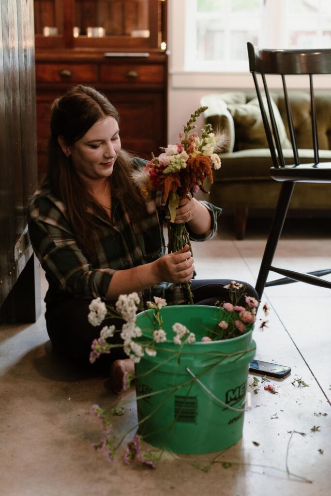 Bridesmaid putting together bridal bouquet for camp wandawega wedding.