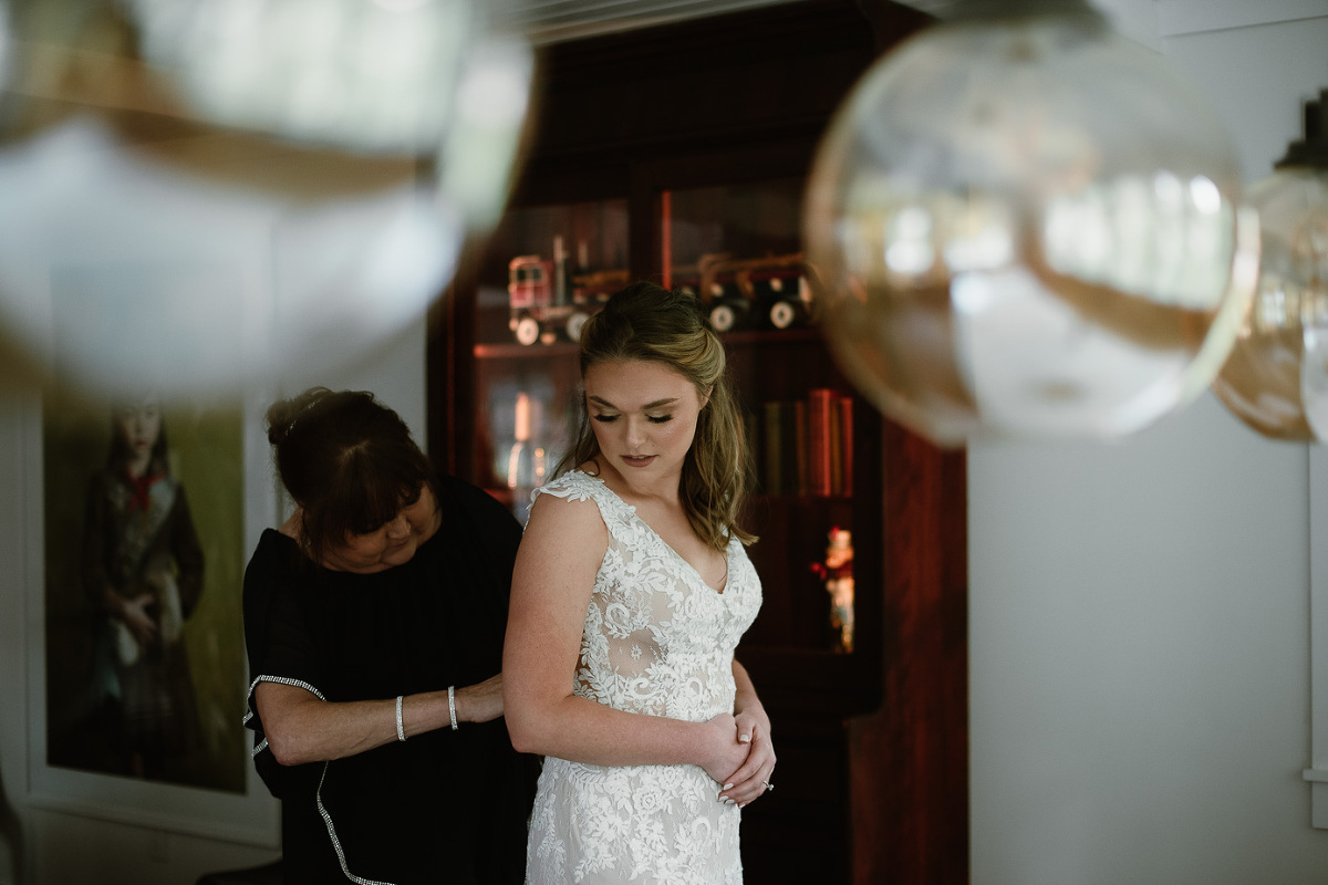 bride putting on dress in bridal suite