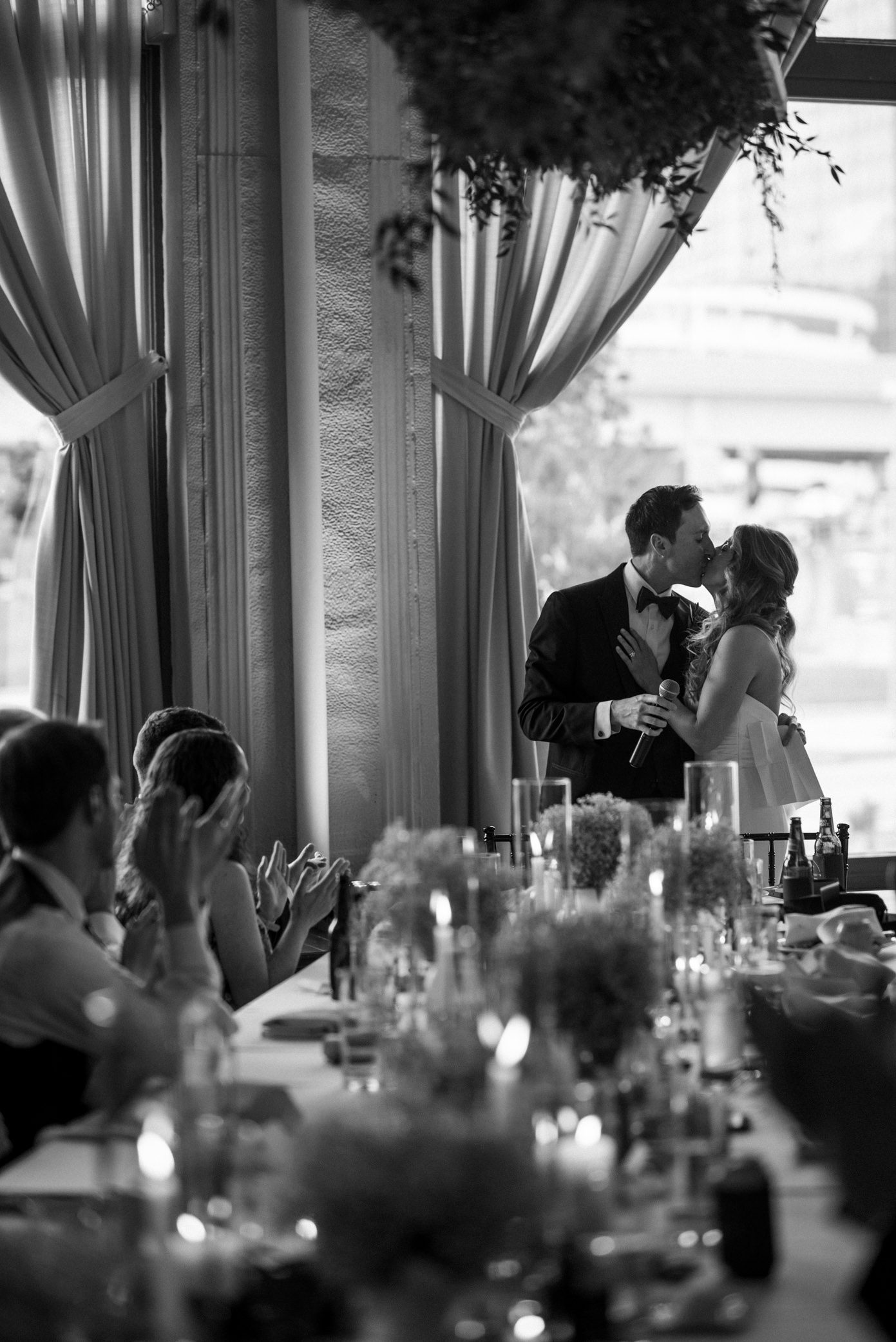 Bride and groom kissing after giving welcome speech