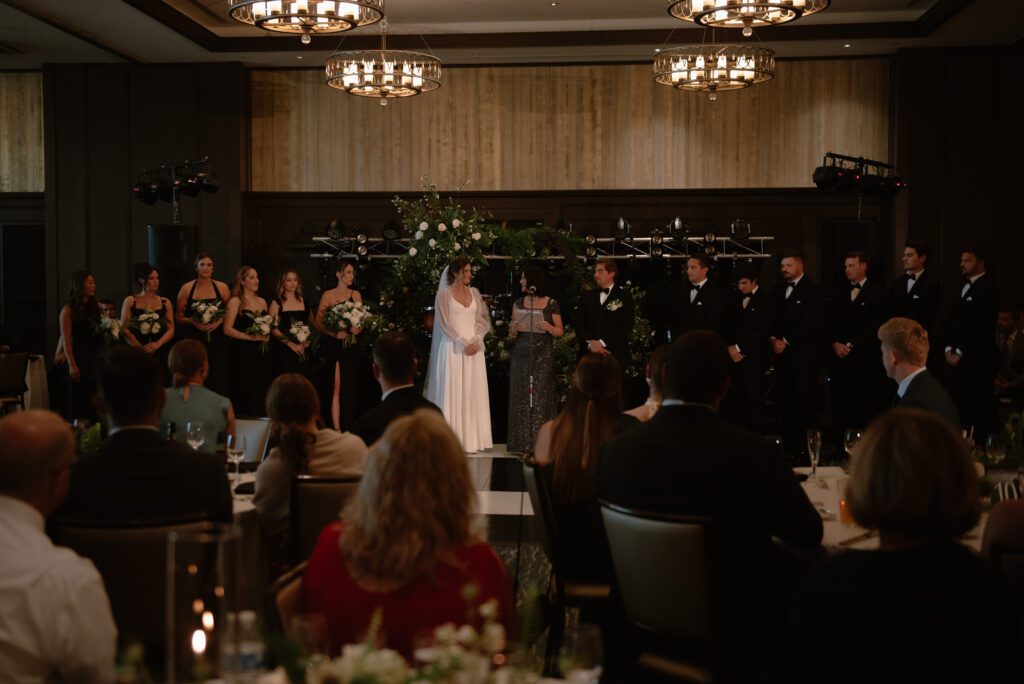 Guests watching ceremony during rainy day wedding at The Edgewater Hotel.